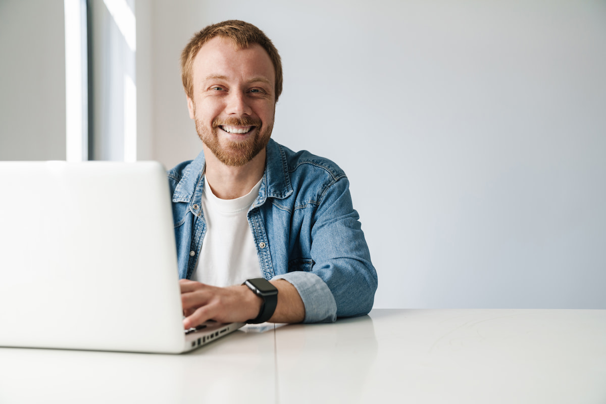 Robert sorride al laptop mentre lavora con aivie